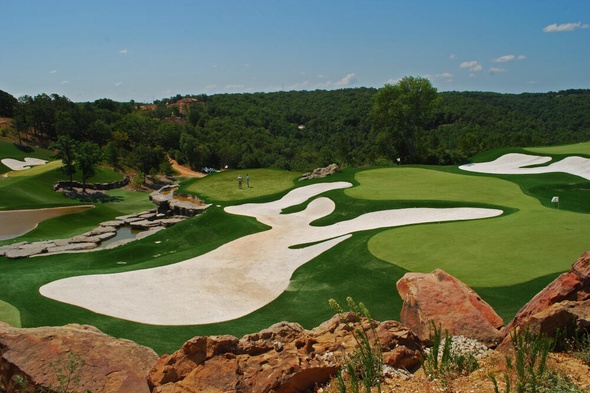 Charlotte lush green synthetic grass golf course with white sand bunkers and blue sky